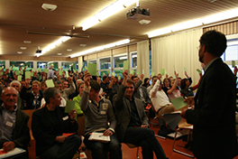 Anwesende der Gründungsversammlung heben den grünen Stimmzettel als Zeichen ihrer Zustimmung zur Gründung des Vereins Alumni Sportwissenschaft Universität Bern.