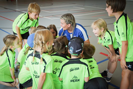 Eine Leiterin eines Sportcamps mit Kinder.