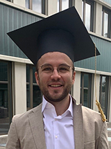 Merlin Örencik mit Doktorenhut.